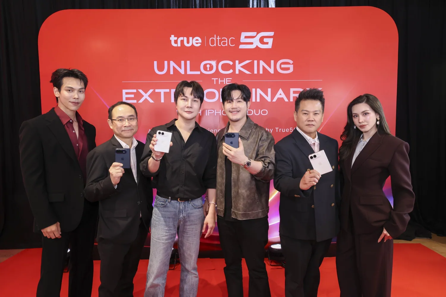 ผู้บริหารทรู คอร์ปอเรชั่น และแขกรับเชิญถือ iPhone DUO ร่วมกันหน้าแบ็กดร็อป